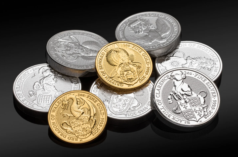 Various gold and silver coins in a pile on a black background
